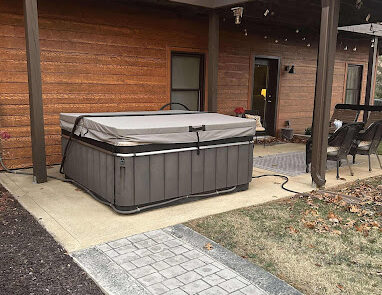 Raised hot tub on patio under deck
