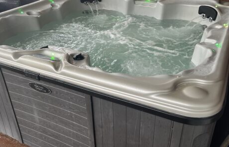 Square hot tub filled with bubbling water, green LED lighting