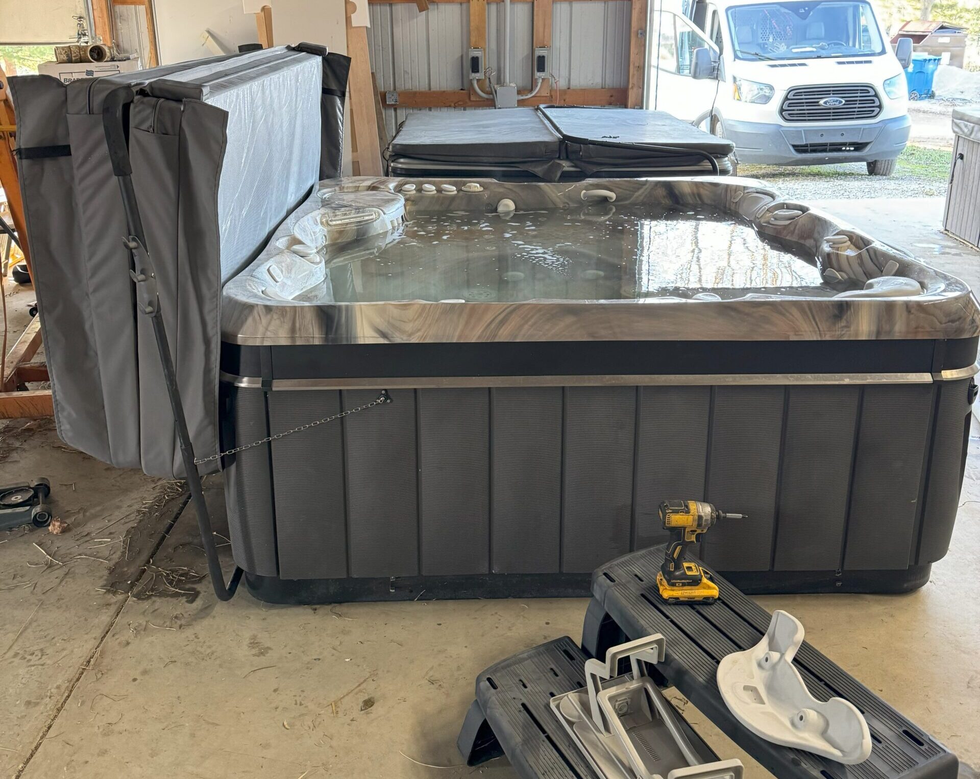 Testing restored hot tub in large, garage-type shed workshop.